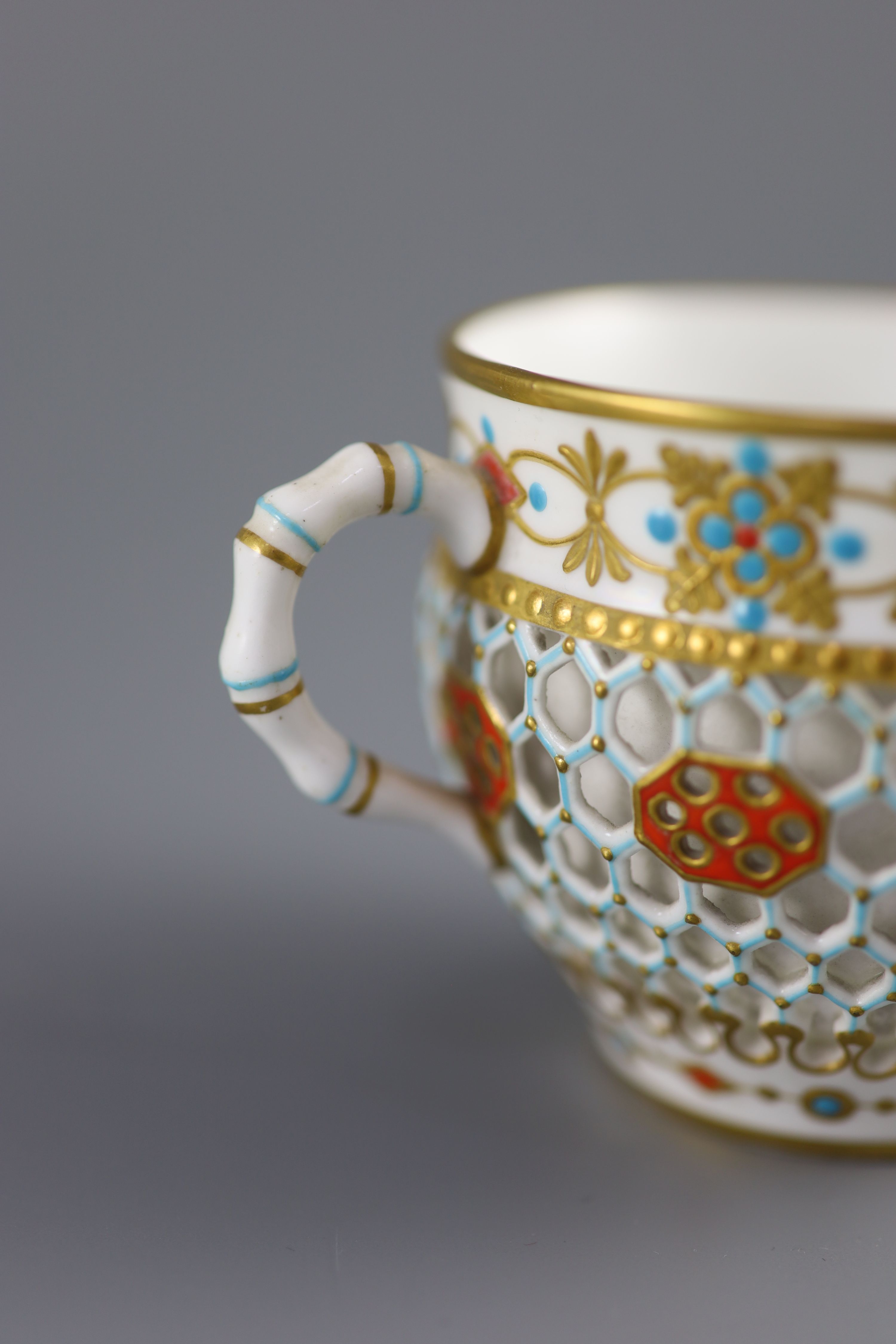 A Royal Worcester 'jewelled' and reticulated cup and saucer